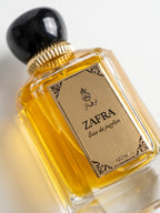 ZAFRA Eau de parfum 100 ml, sticlă transparentă — detaliu etichetă și capac